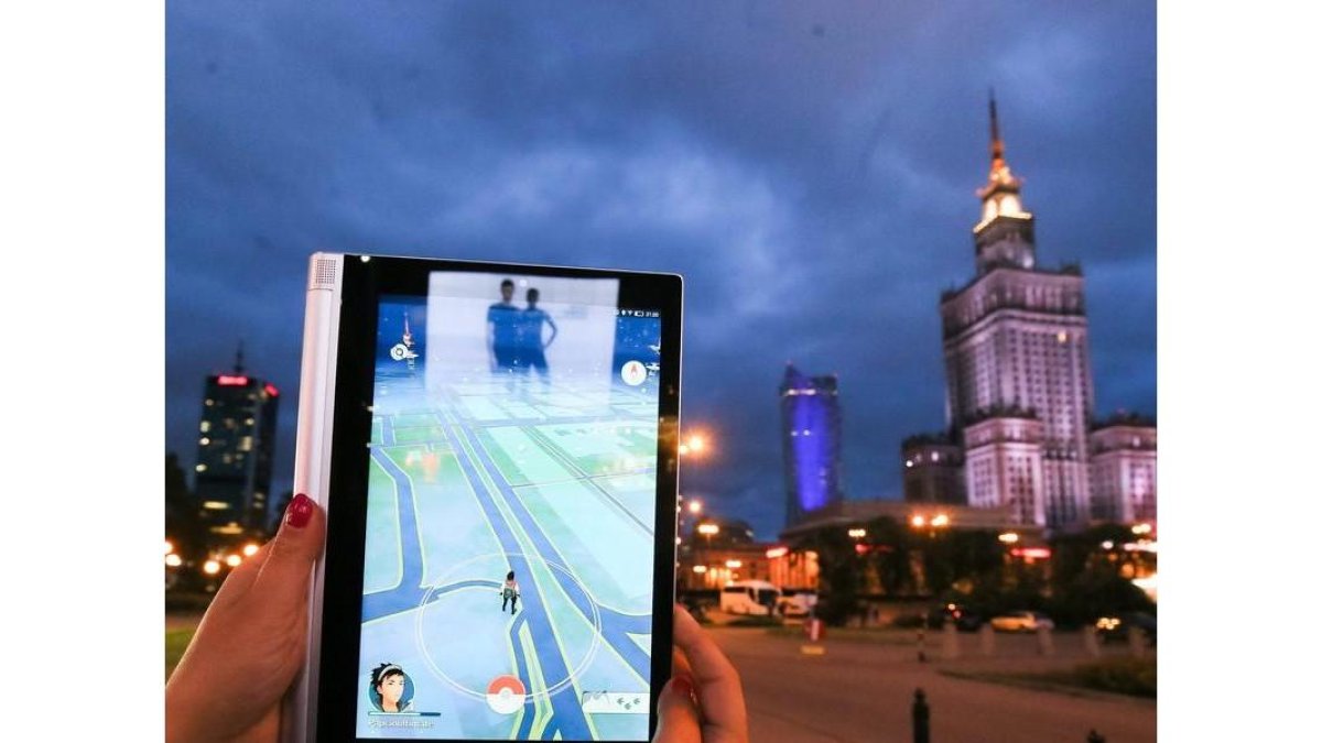 Una joven juega con la aplicación Pokemon Go cerca al Palacio de la Ciencia y la Cultura de Varsovia.