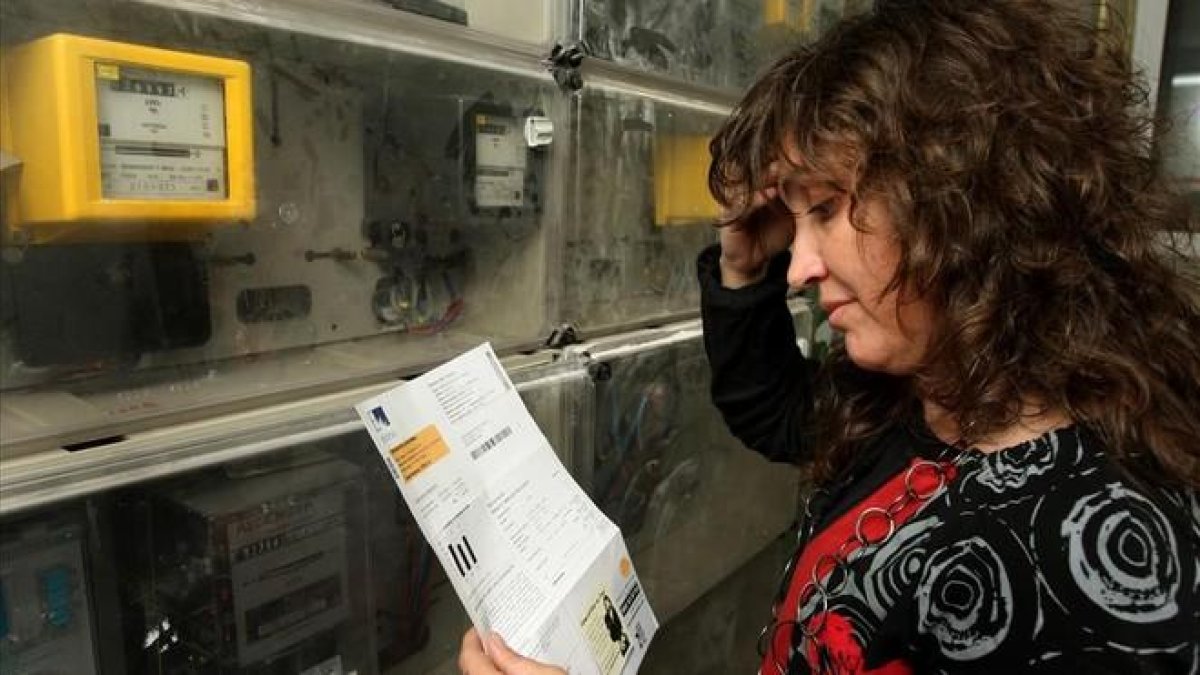Una mujer mira una factura real de Endesa.