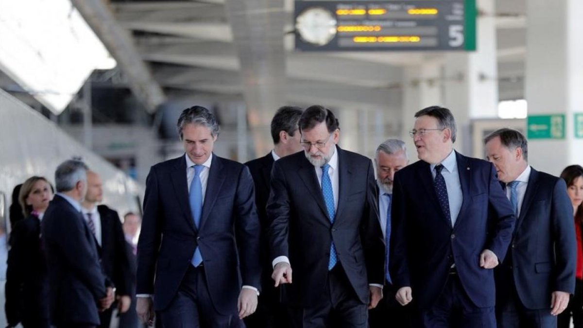 Mariano Rajoy, entre el ministro de Fomento, Íñigo de la Serna (izquierda en la foto), y el presidente de la Comunitat Valenciana, Ximo Puig, en la estación Joaquín Sorolla de Valencia antes de la salida hacia Castellón.