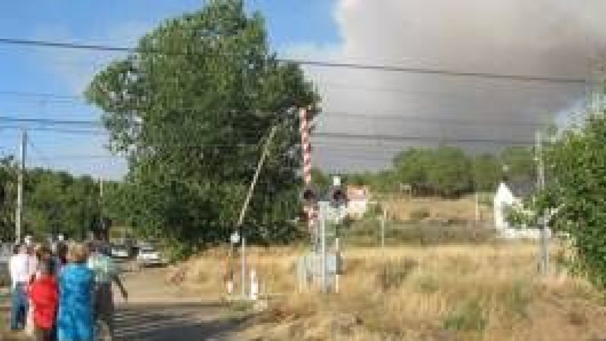 Vecinos de Porqueros observan en las cercanías de la vía del tren el fuego del domingo