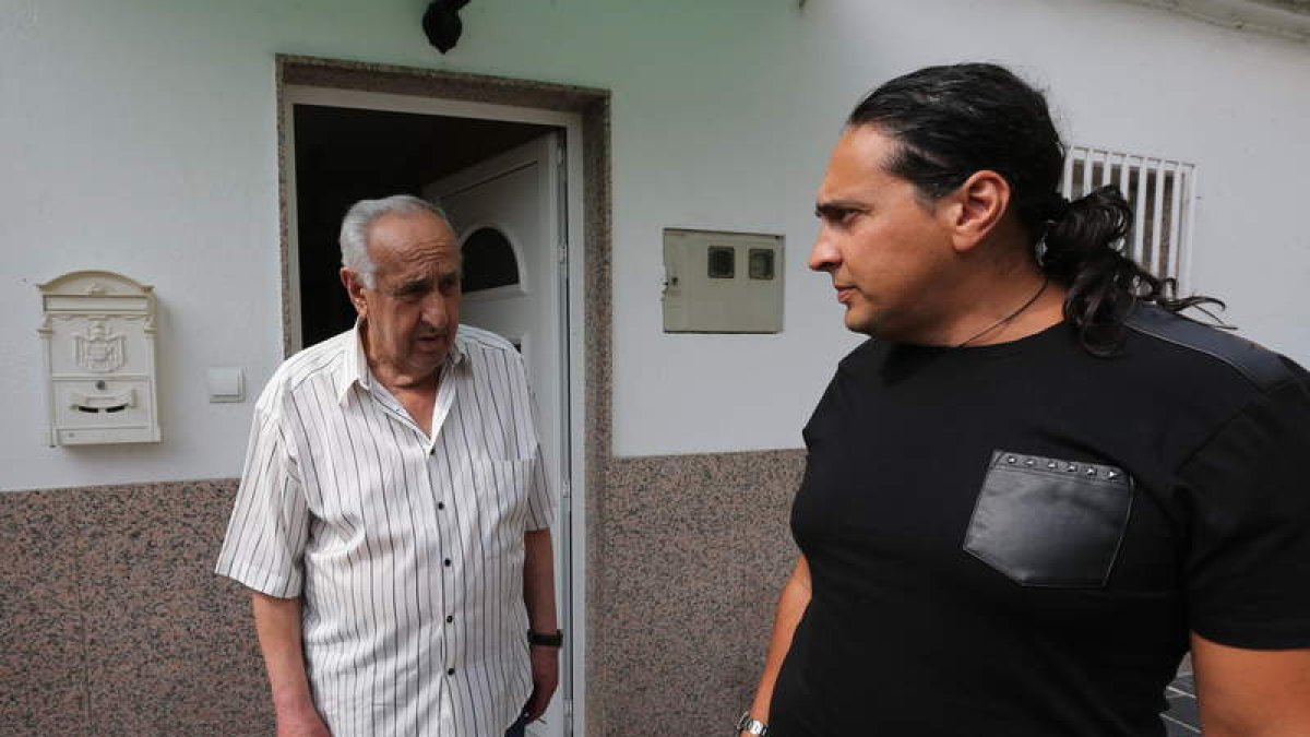 Luis Prada, junto a su hijo, en la puerta de su casa, situada en el barrio de Flores del Sil.