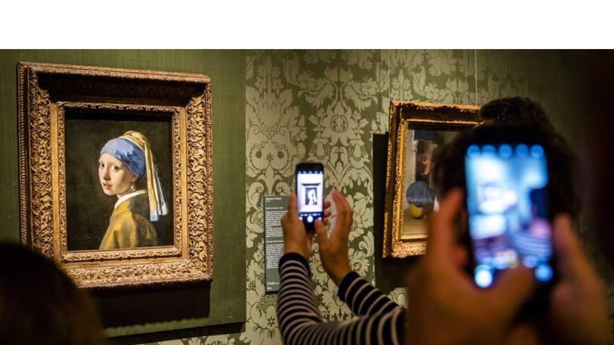 Visitantes del Museo Mauritshuis de La Haya hacen fotos a ‘La joven de la perla’. BART MAAT