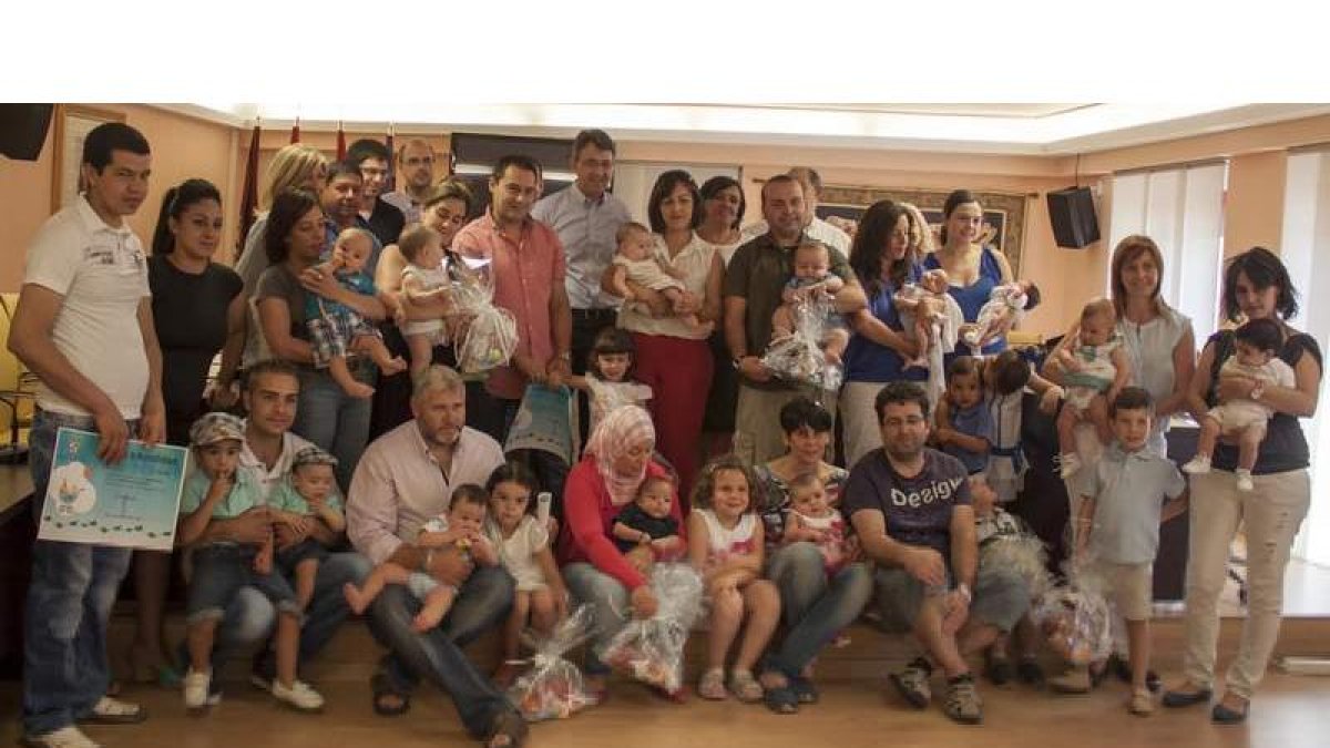 Imagen de grupo de las autoridades y las familias que ayer asistieron a la entrega de los cheques-bebé.