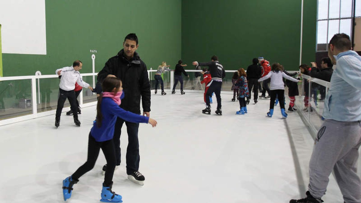 Más de una docena de personas disfrutan del patinaje sobre hielo en la apertura de la pista de La Virgen del Camino.