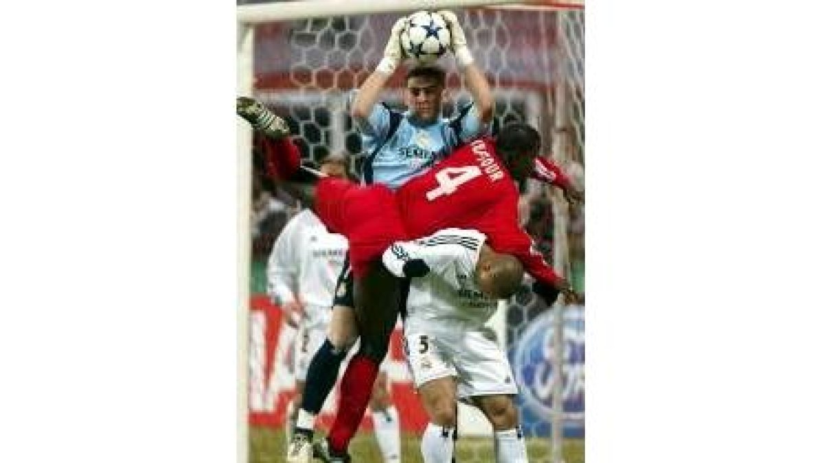 Casillas detiene un balón por alto ante la presión de un contrario
