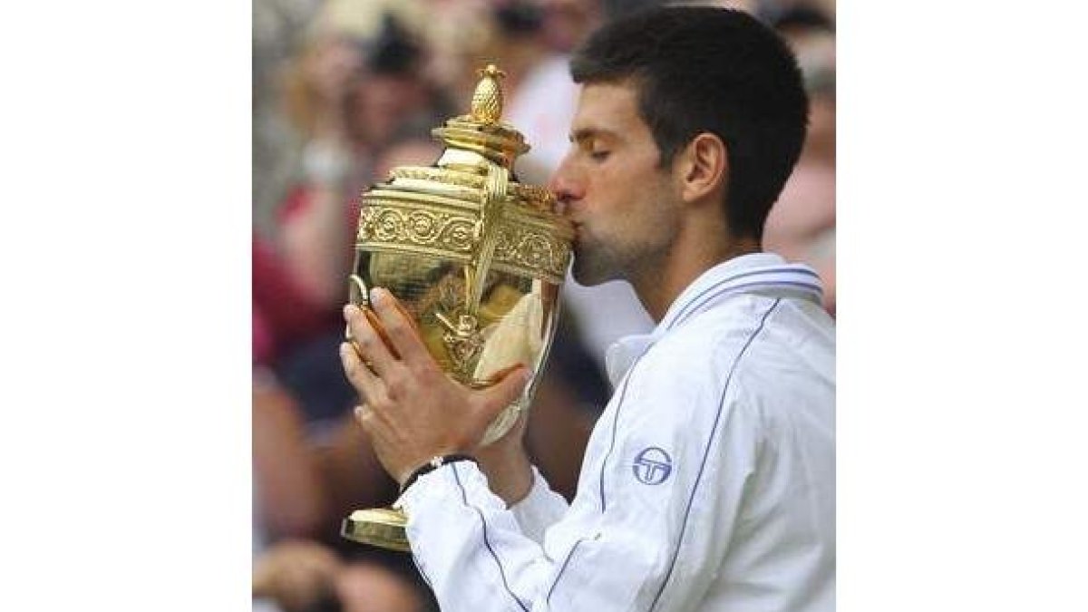 El serbio Novak Djokovic besa su trofeo obtenido al ganarle al tenista español Rafa Nadal en la fina