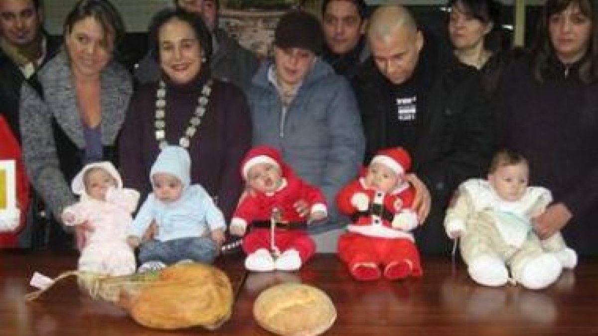 Los cinco niños posaron ayer junto a sus orgullosos padres, un jamón y una hogaza de pan