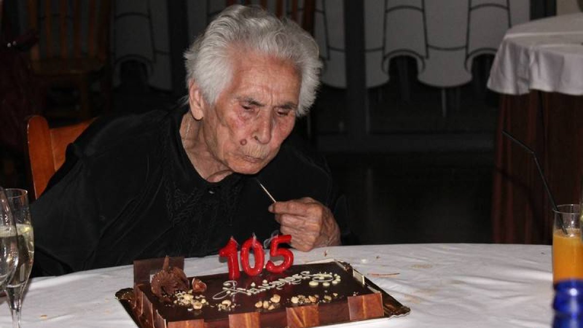 Perpétua López Díaz sopla la tarta con las velas de su 105 cumpleaños que celebró con su numerosa familia