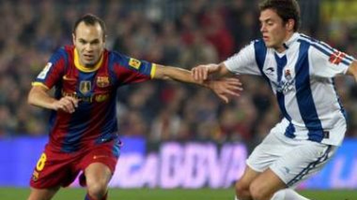 Iniesta controla el balón ante la oposición del centrocampista de la Real Sociedad Gorka Elustondo.