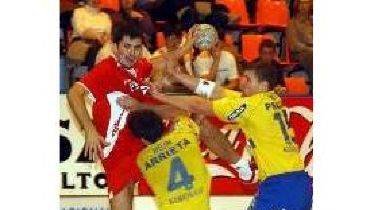 Metlicic trata de realizar un lanzamiento por encima de Unai Arrieta y del esloveno Rolando Praznik