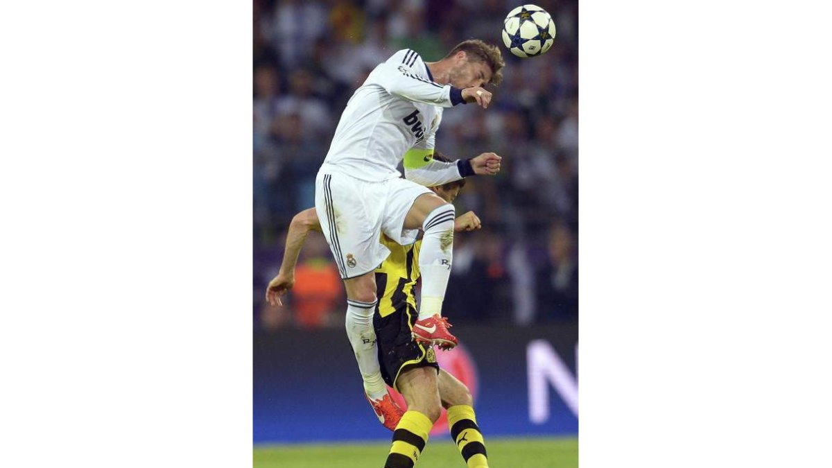 Sergio Ramos lucha por el balón con el delantero polaco Robert Lewandowski.