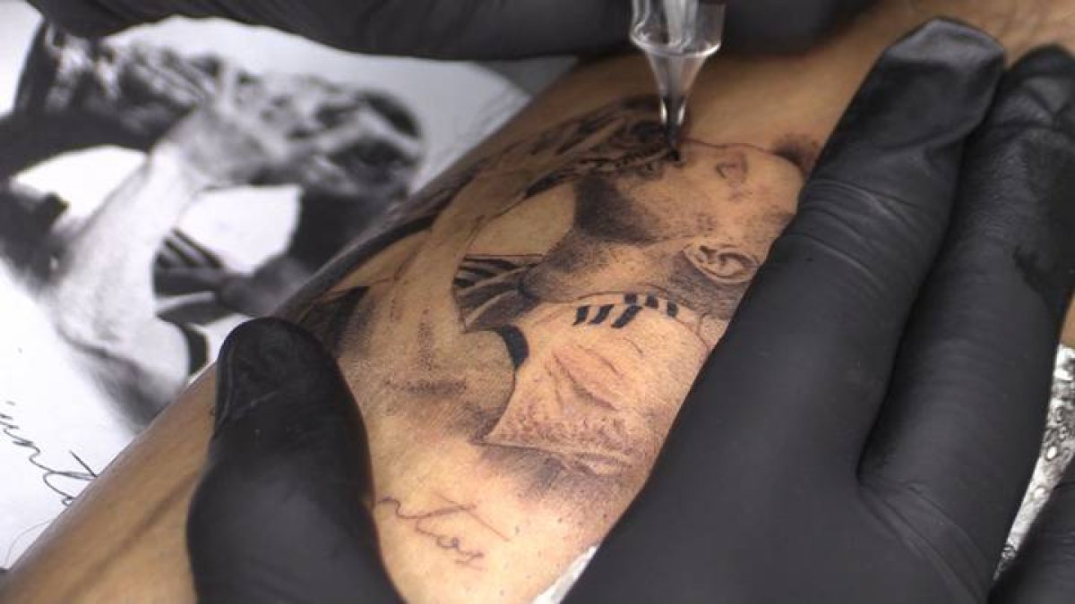 Una persona se hace un tatuaje de Lionel Messi besando la Copa del Mundo, el 20 de diciembre de 2022 en Rosario (Argentina). RODRIGO GARCÍA
