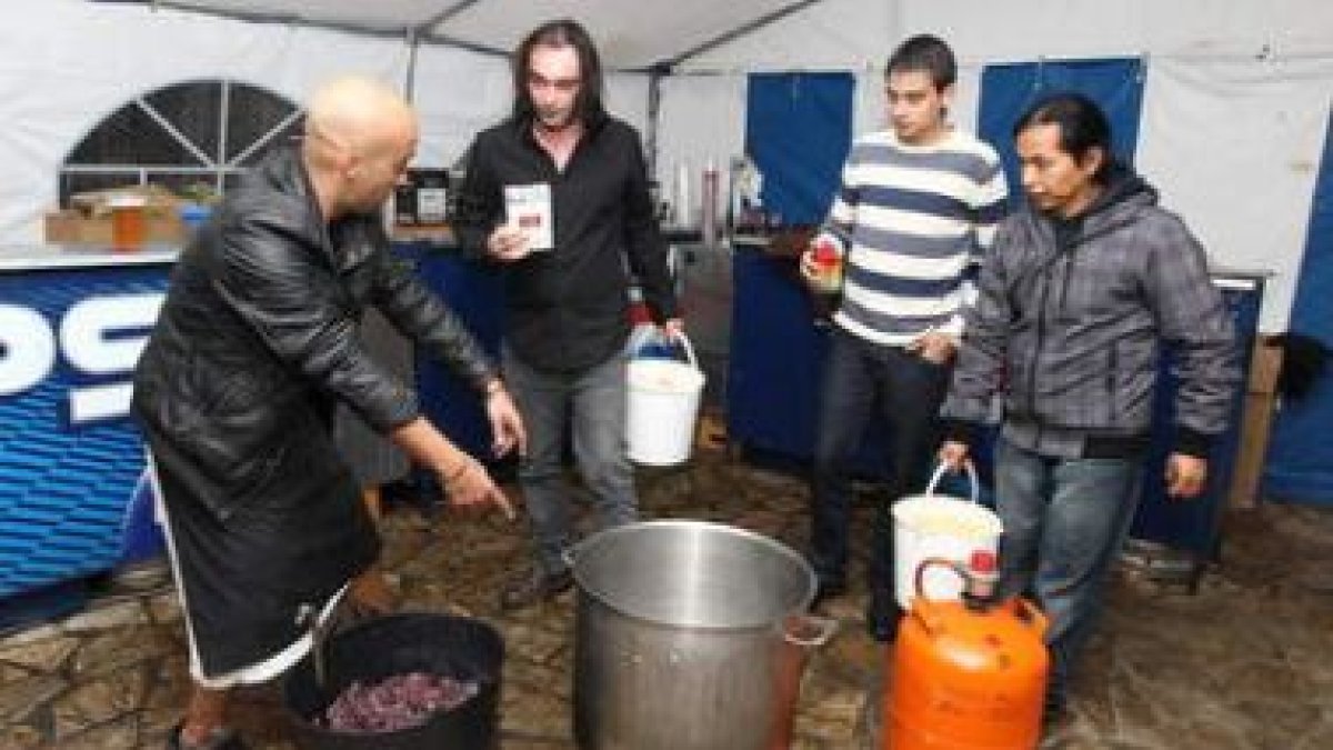 A la izquierda Félix Álvarez, ayer junto a otros amigos preparando la fiesta bajo una carpa.