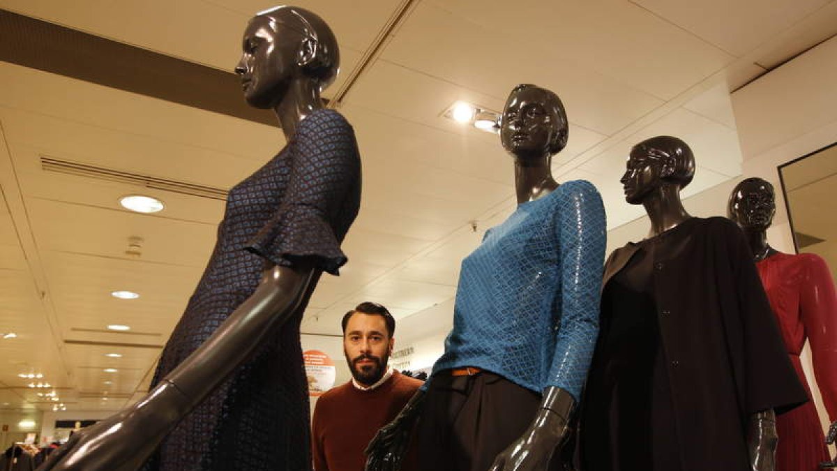 El diseñador Juanjo Oliva posa con unos maniquíes con sus diseños en El Corte Inglés.