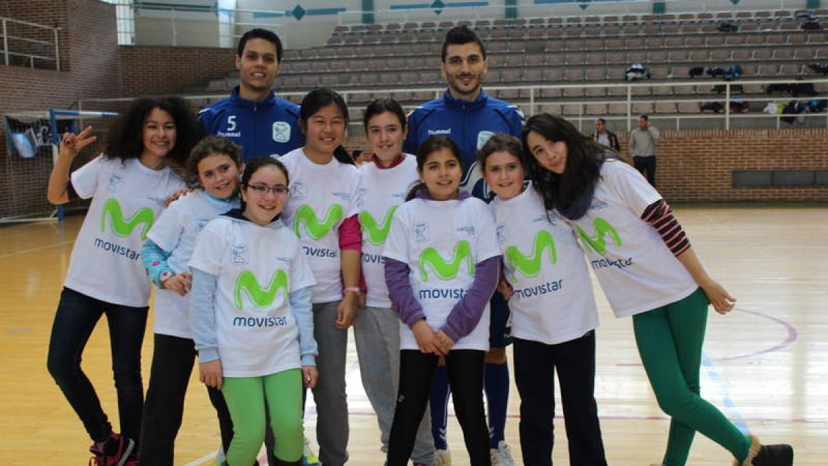 Un grupo de niñas posa después del partido con dos de los jugadores del Inter Movistar.
