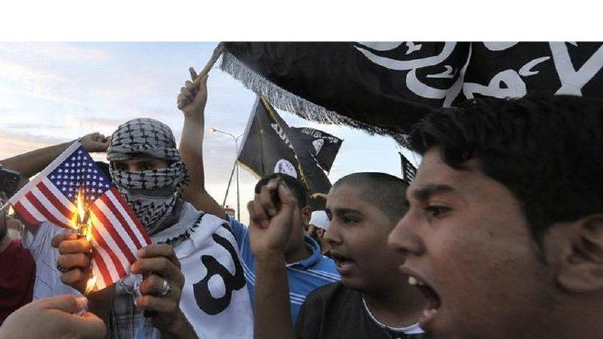 Manifestantes libios queman una bandera de EEUU en protesta por la detención de Al-Libi, en Benghazi.