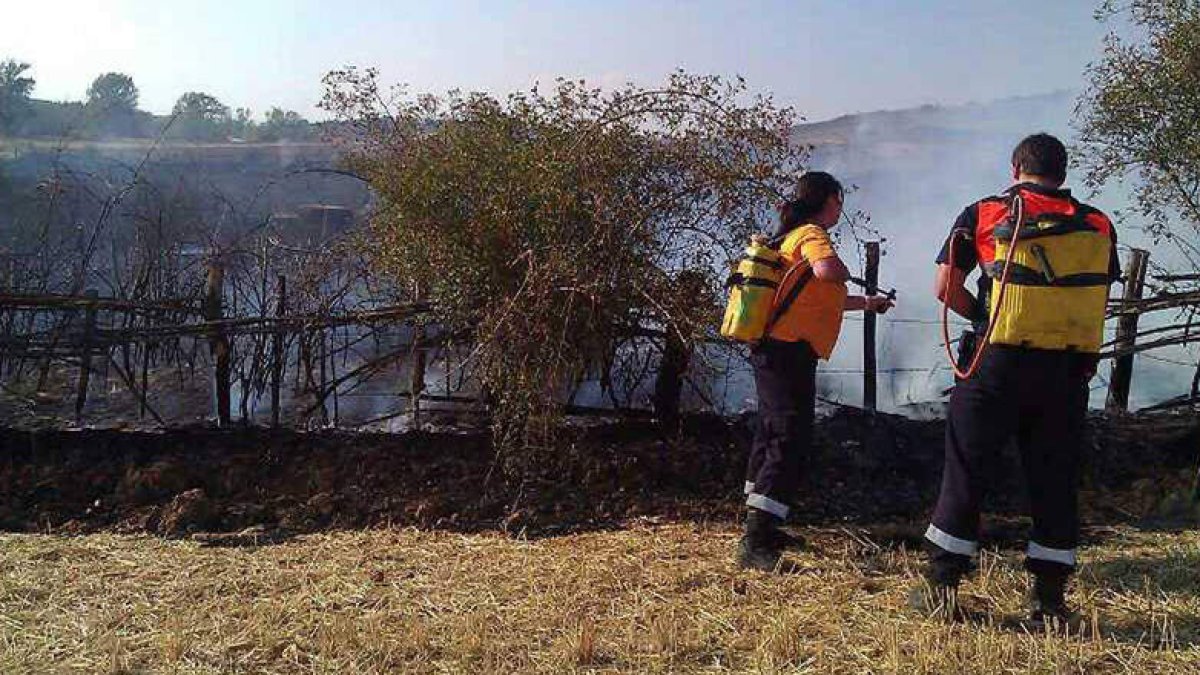 Dos agentes sofocan las llamas del incendio del pasado miércoles.