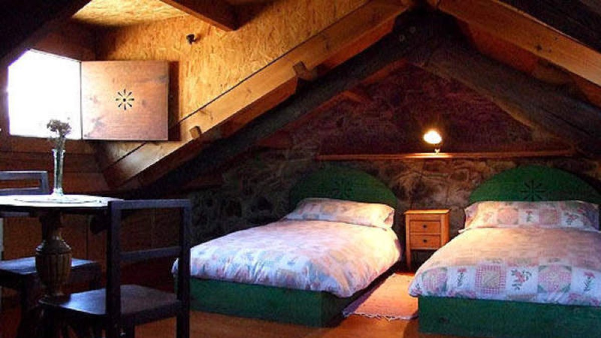 Dormitorio y fachada de la casa ruralLa Nogala, en Labaniego.