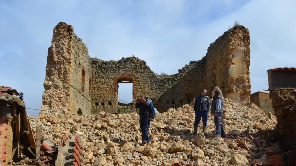 El alcalde, el presidente de la junta vecinal y otros vecinos sobre los escombros del muro del castillo derrumbado. MEDINA