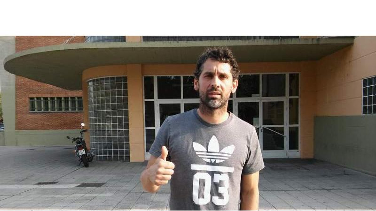 El extremo leonés, ayer tras el entrenamiento, hace un gesto de optimismo ante las puertas del Palacio de Deportes. DL