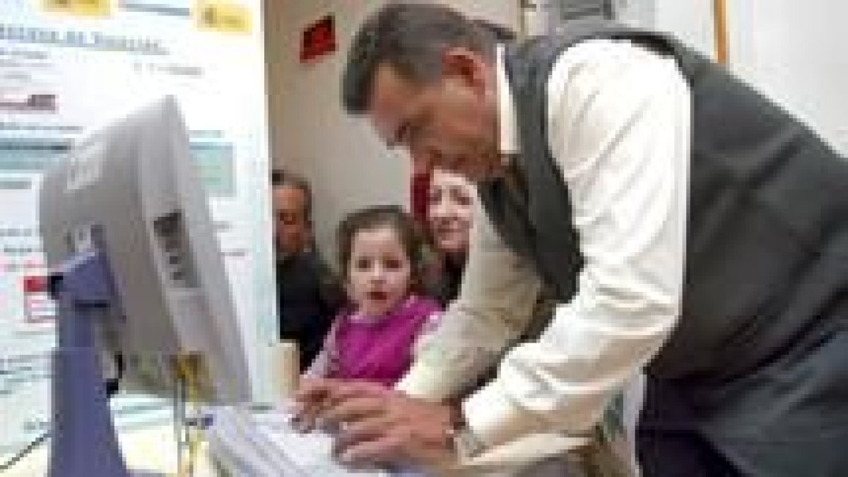 Uno de los vecinos de El Hoyo de Pinares, Ávila, emite su voto a través de la pantalla del ordenador