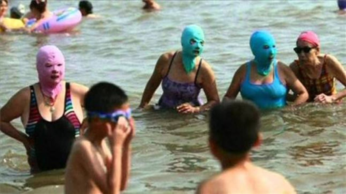 Bañistas en una playa de China luciendo un 'Facekini'