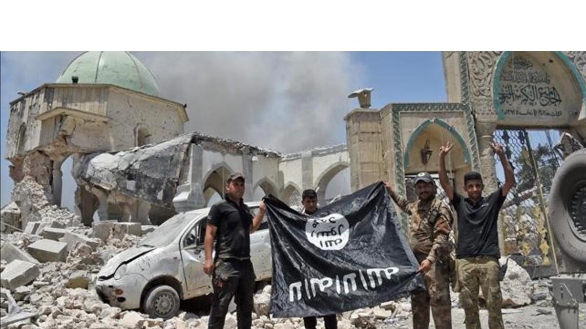 Miembros del Servicio Iraquí de Contraterrorismo hace la señal de la victoria tras la conquista de Mosul.