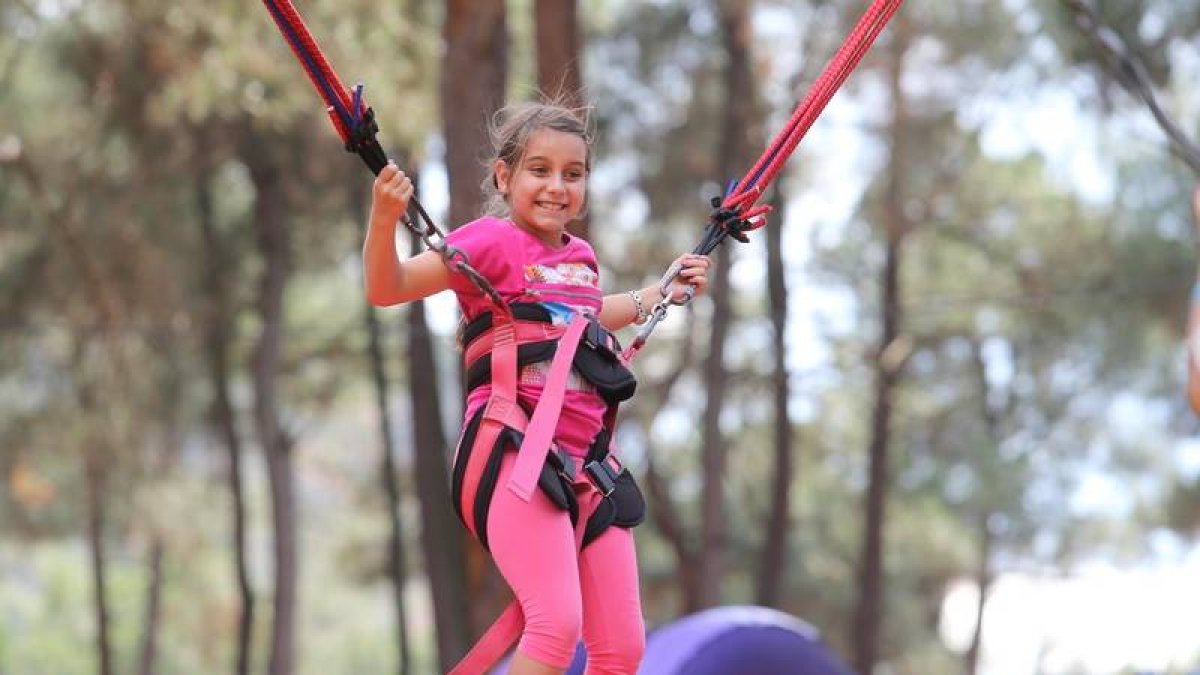 Una niña disfruta de los saltos con la goma elástica