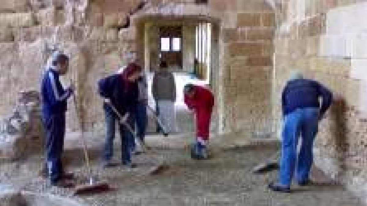 Los voluntarios limpian la parte del antiguo comedor de los monjes del monasterio de Sandoval