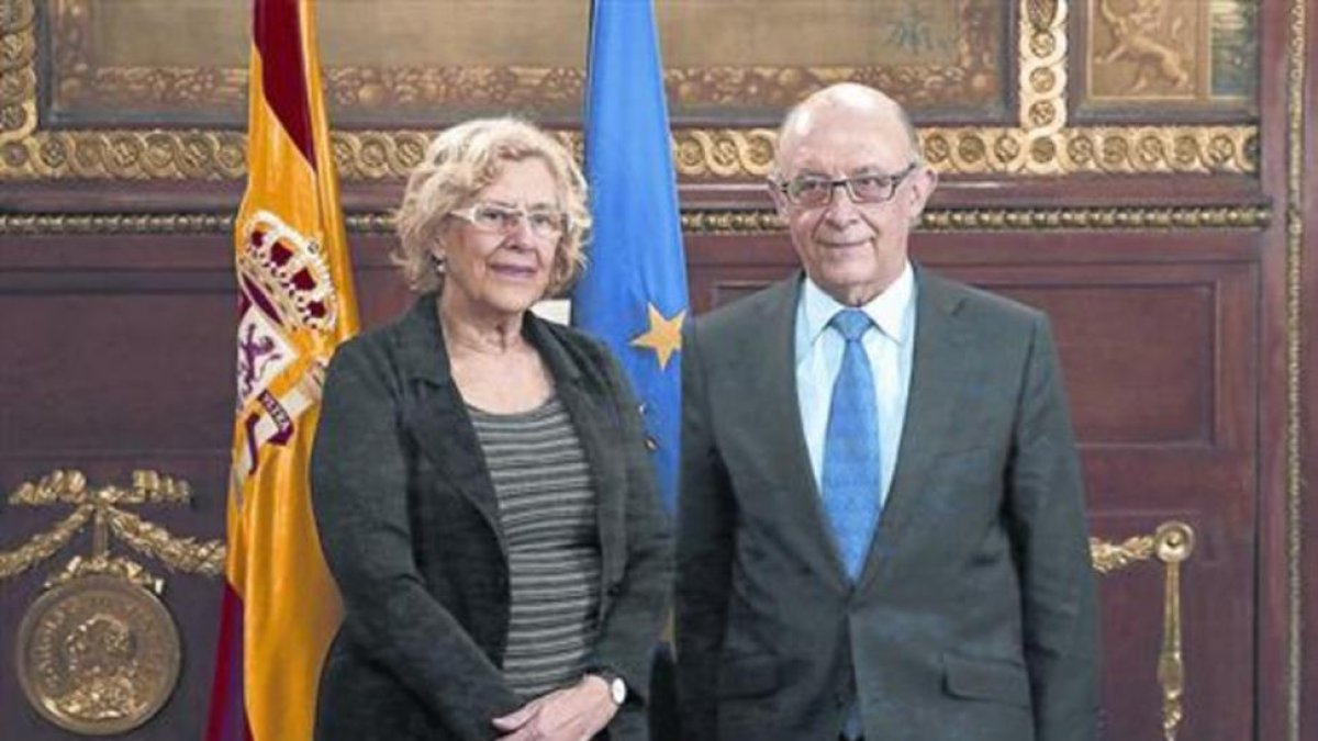 La alcaldesa de Madrid, Manuela Carmena, y el ministro de Hacienda, Cristóbal Montoro, en una reunión el pasado año.