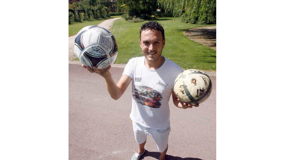 David Vila posa con dos de los balones que le firmaron algunos de sus compañeros