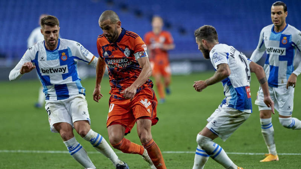 Yuri trata de marcharse de Calero y Miguelón en una acción de la segunda mitad del choque de ayer en el RCDE Stádium. SAMUEL CASTRO