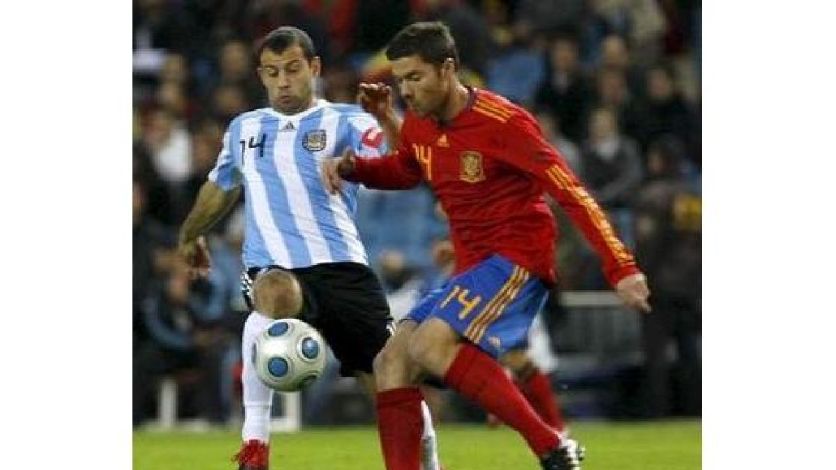 El centrocampista argentino Mascherano lucha un balón con Xabi Alonso.