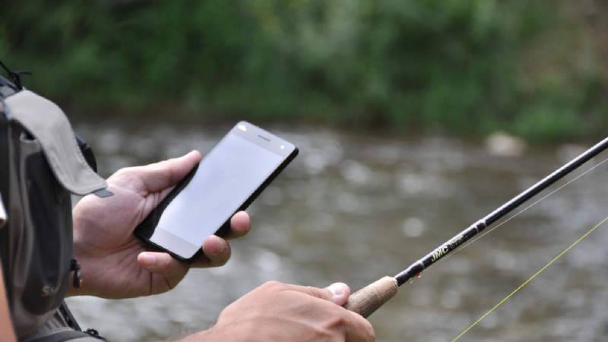 Un pescador con la aplicación MyFishingMaps instalada en su teléfono móvil.