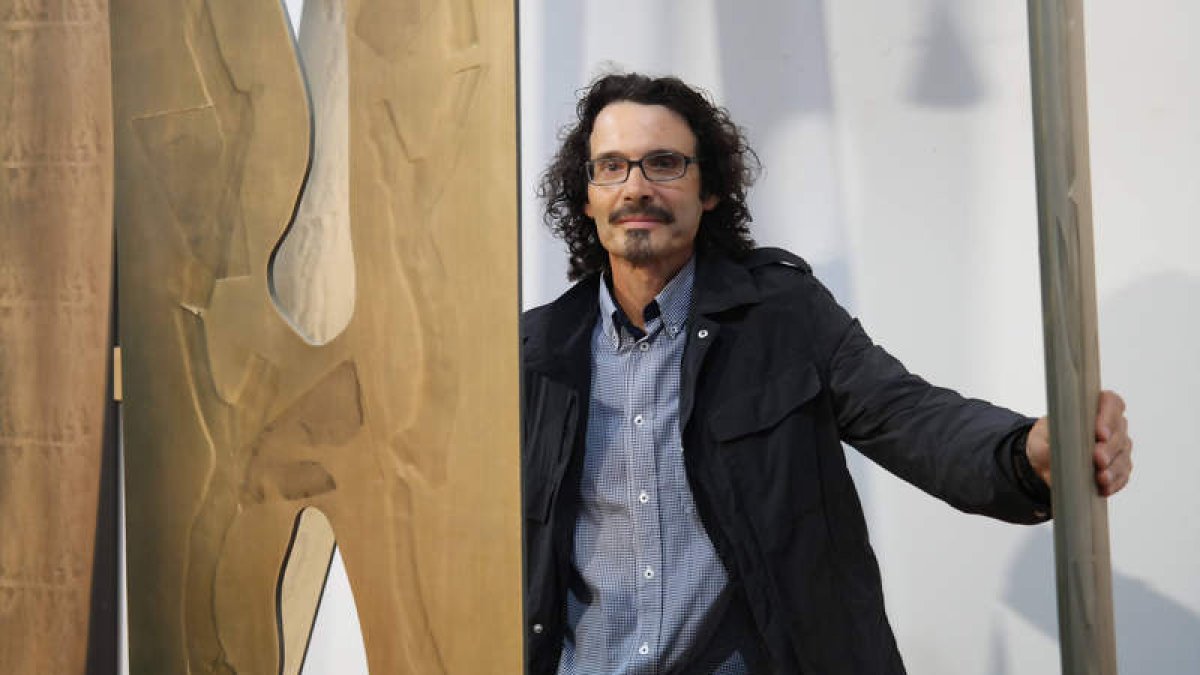 El artista leonés Santocildes posa con una de las obras que integran la exposición.