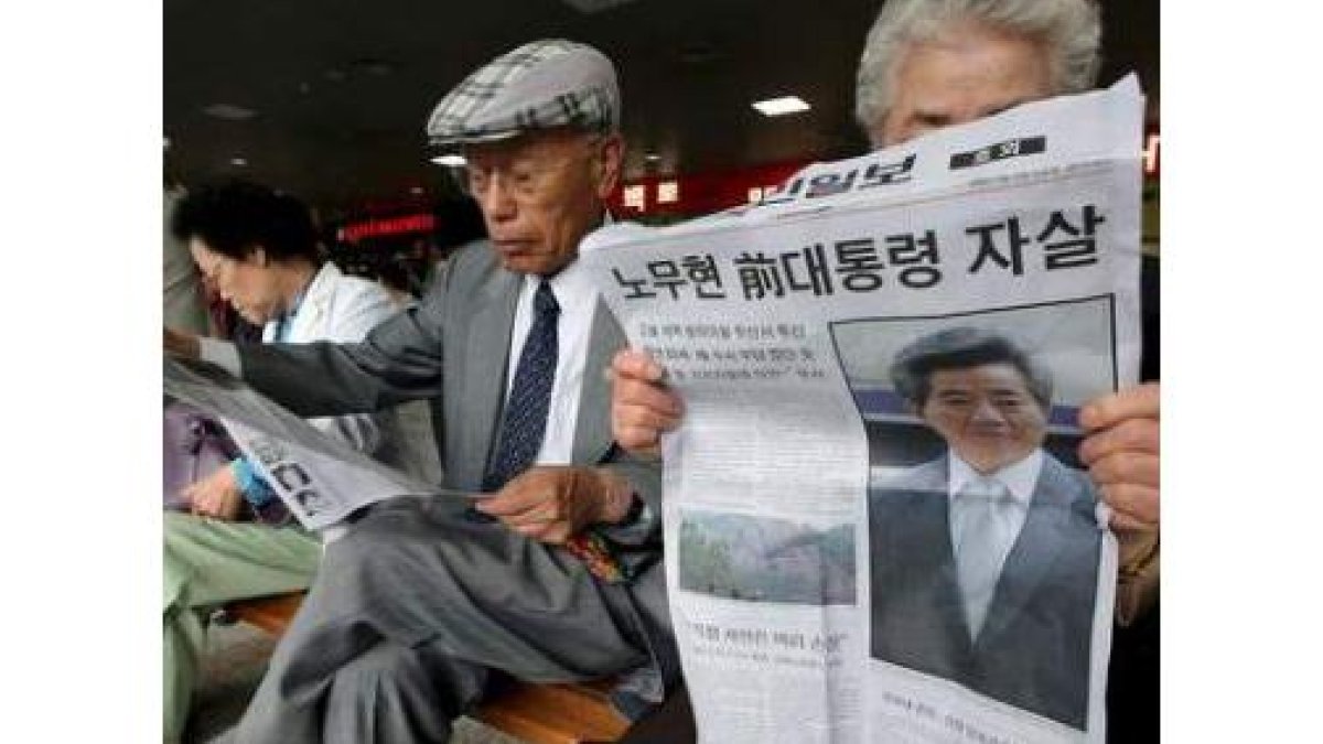 Varias personas leen la noticia de la muerte de Roh Moo-hyun