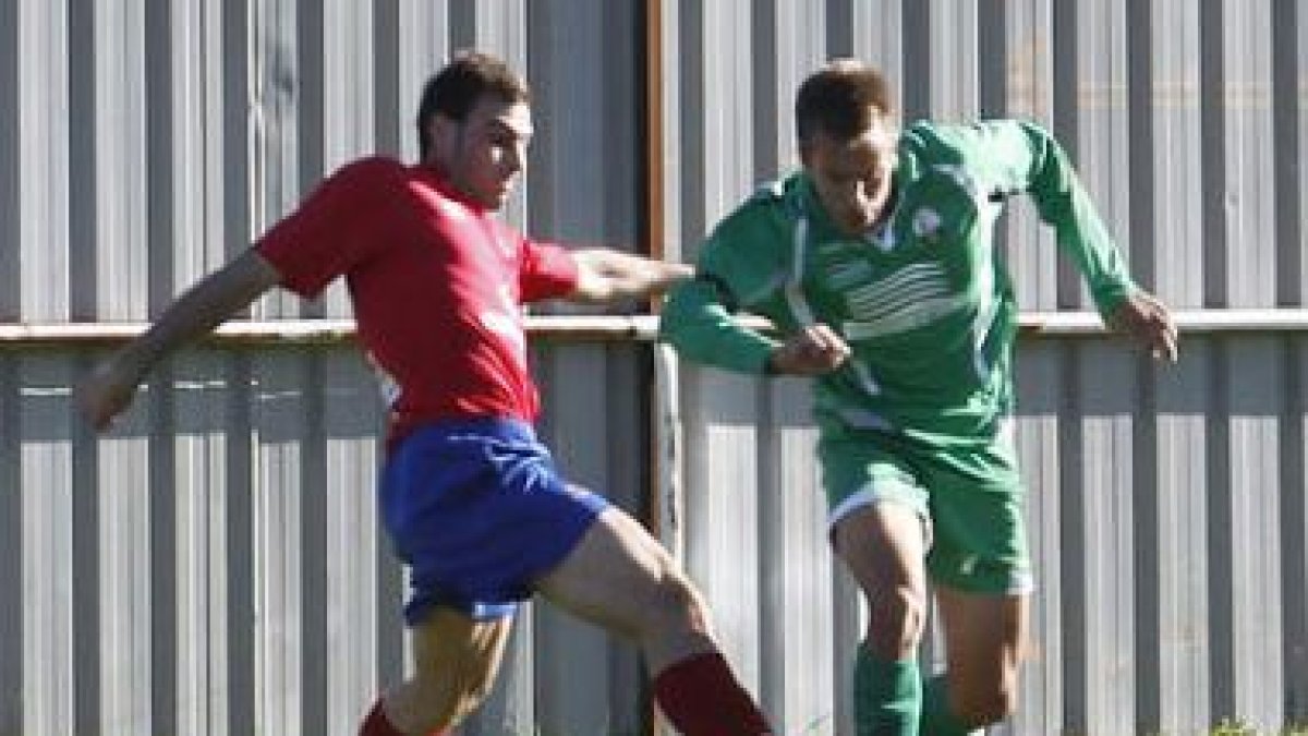 Álvaro, a la derecha, se lleva el balón a pesar de su rival.