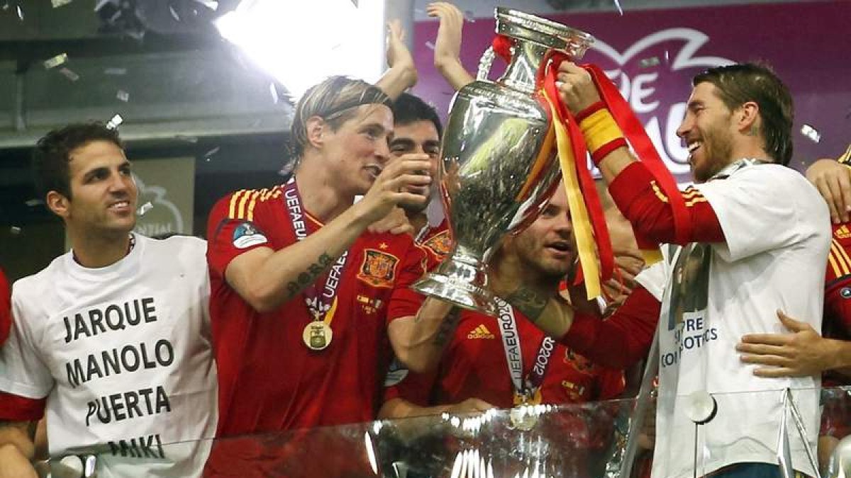 Los jugadores posan con la copa y algunos, como Fábregas a la izquierda, y Ramos honraron en sus camisetas la memoria de sus cuatro compañeros desaparecidos.