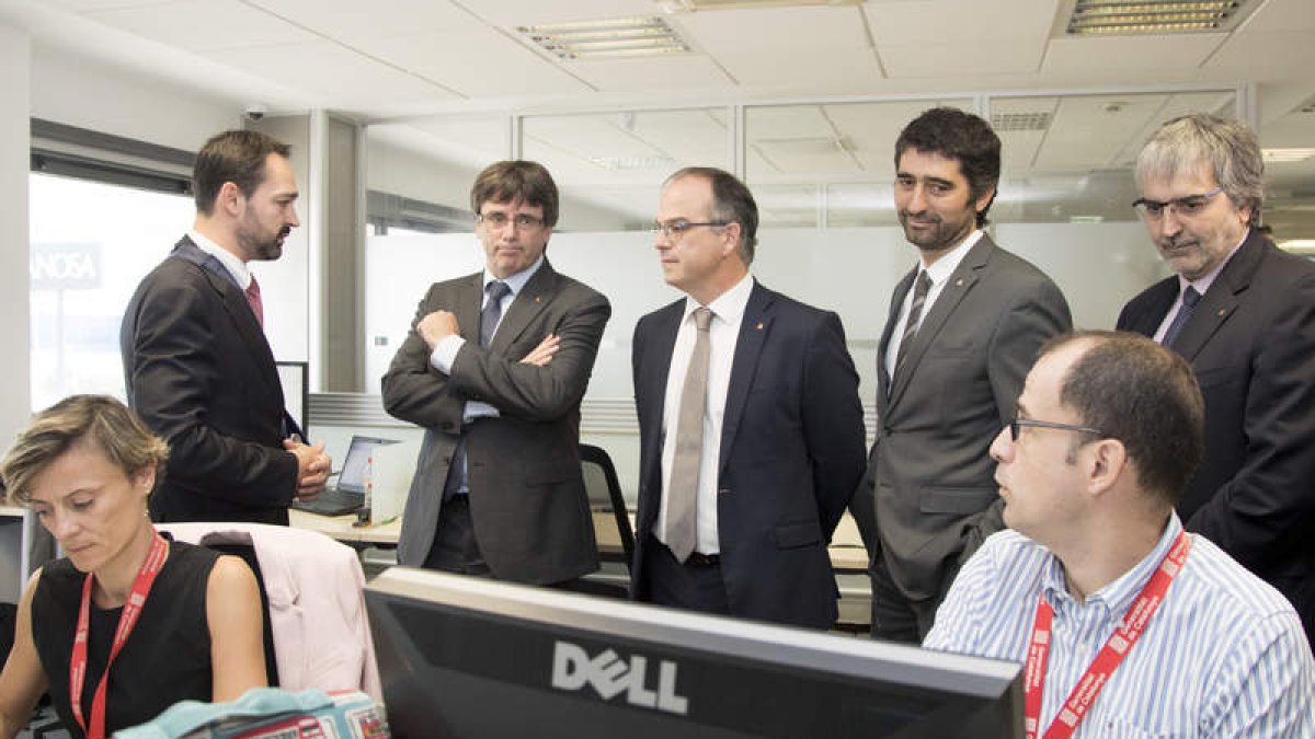 Carles Puigdemont (2i), durante la visita a la Agencia de Ciberseguridad de Cataluña. MARTA PÉREZ