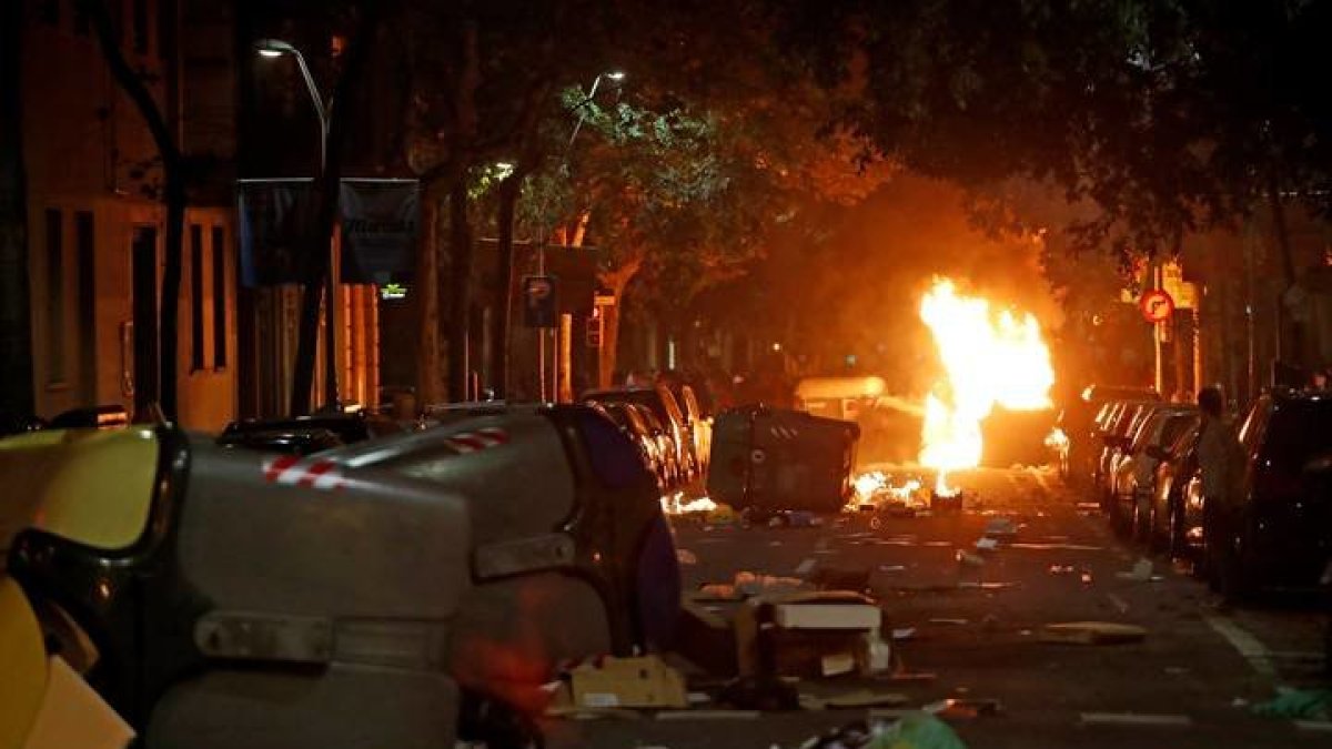 Contenedores volcados y ardiendo durante disturbios. TONI ALBIR