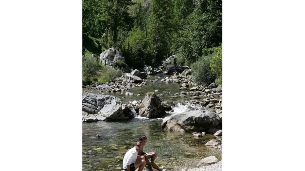 Unos turistas descansan en la zona de la ruta del Cares.