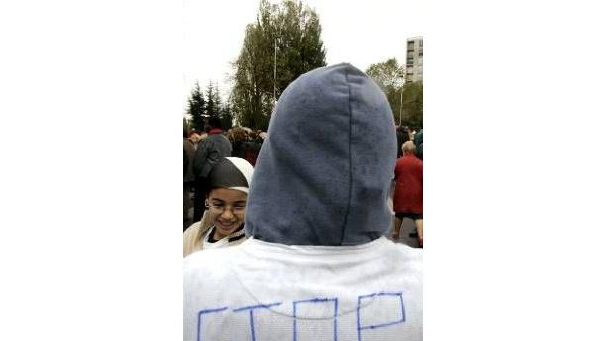 Un joven de un suburbio de París muestra su camiseta con la palabra Stop pintada a la espalda