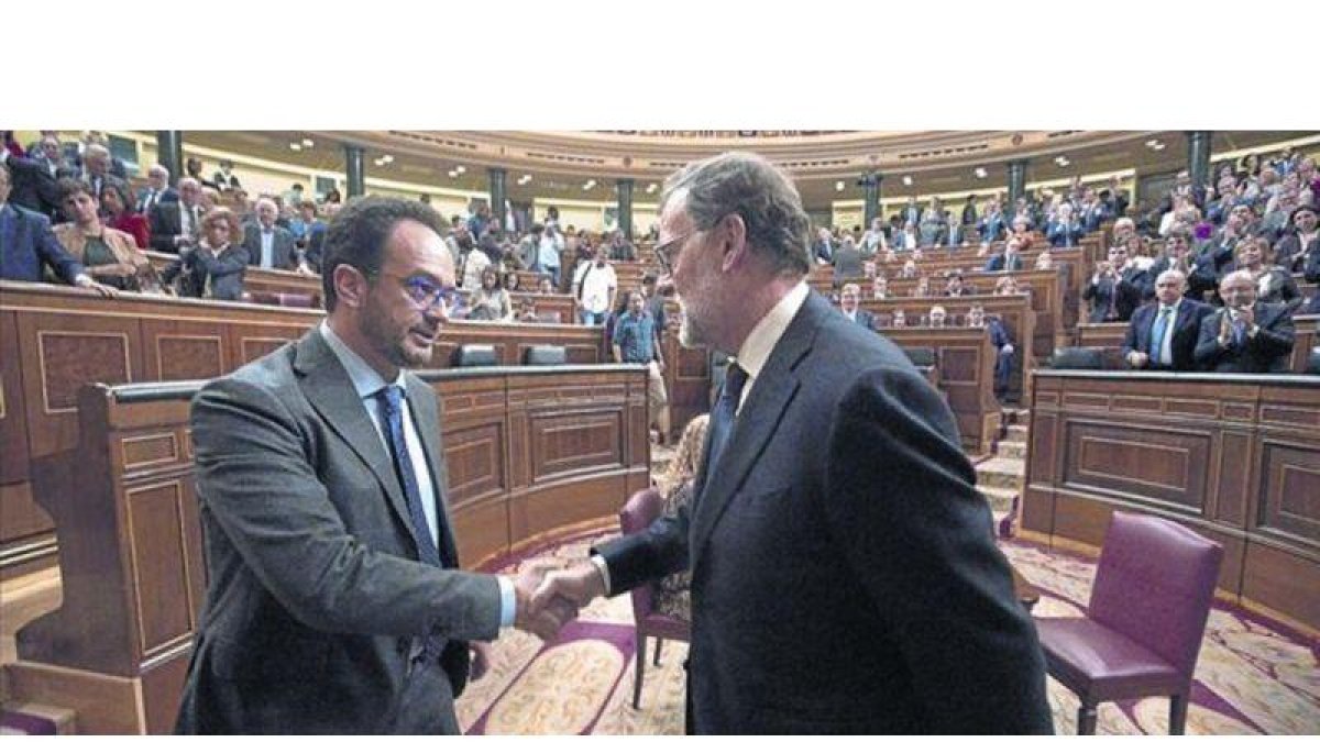 Mariano Rajoy y el socialista Antonio Hernando se dan la mano tras la segunda votación del pleno de investidura.