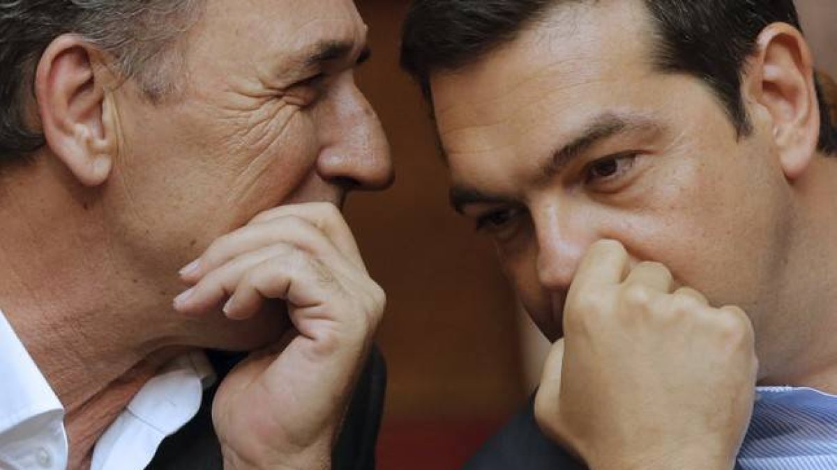 El primer ministro griego, Alexis Tsipras, habla con su titular de Economía, Giorgos Stathakis, este viernes en el Parlamento.