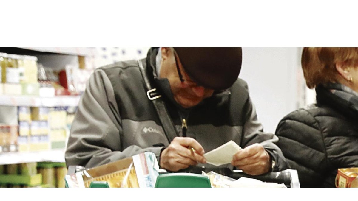 Un hombre revisa la cuenta de su compra en un supermercado. DL