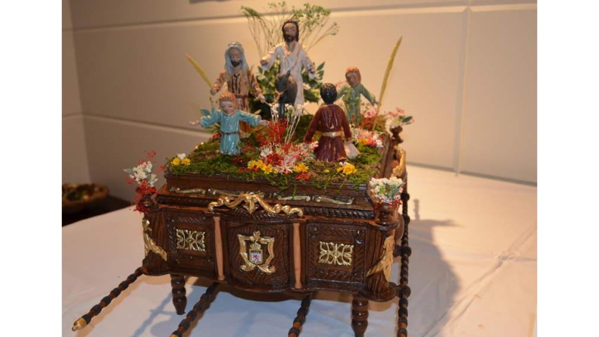La imagen muestra algunas de las reproducciones de tronos de pasos de Semana Santa que se exponen en Santa María del Páramo.