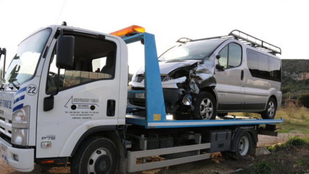 Una grúa retira la furgoneta en la que viajaba el conductor que ha provocado el accidente.