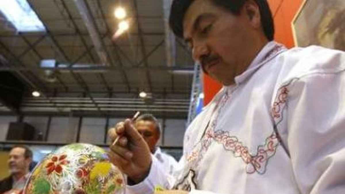 Un mexicano pinta un jarrón en el stand de su país montado en la XXIX edición de Fitur