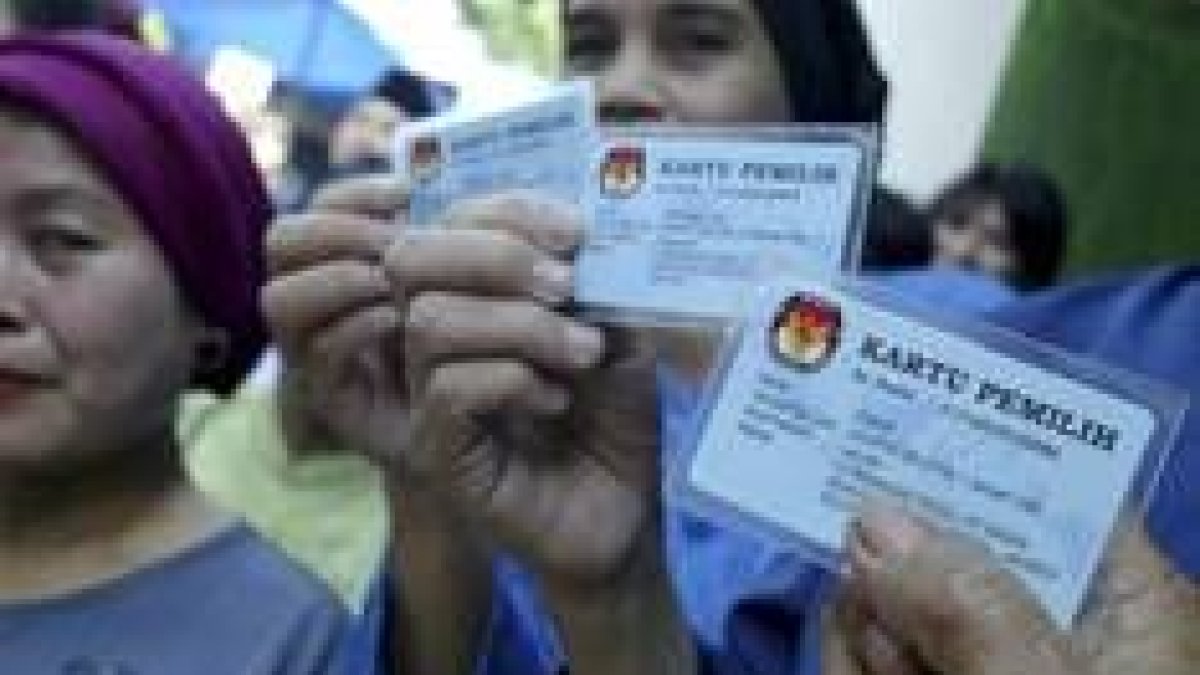 Un grupo de indonesas muestran sus carnés para votar
