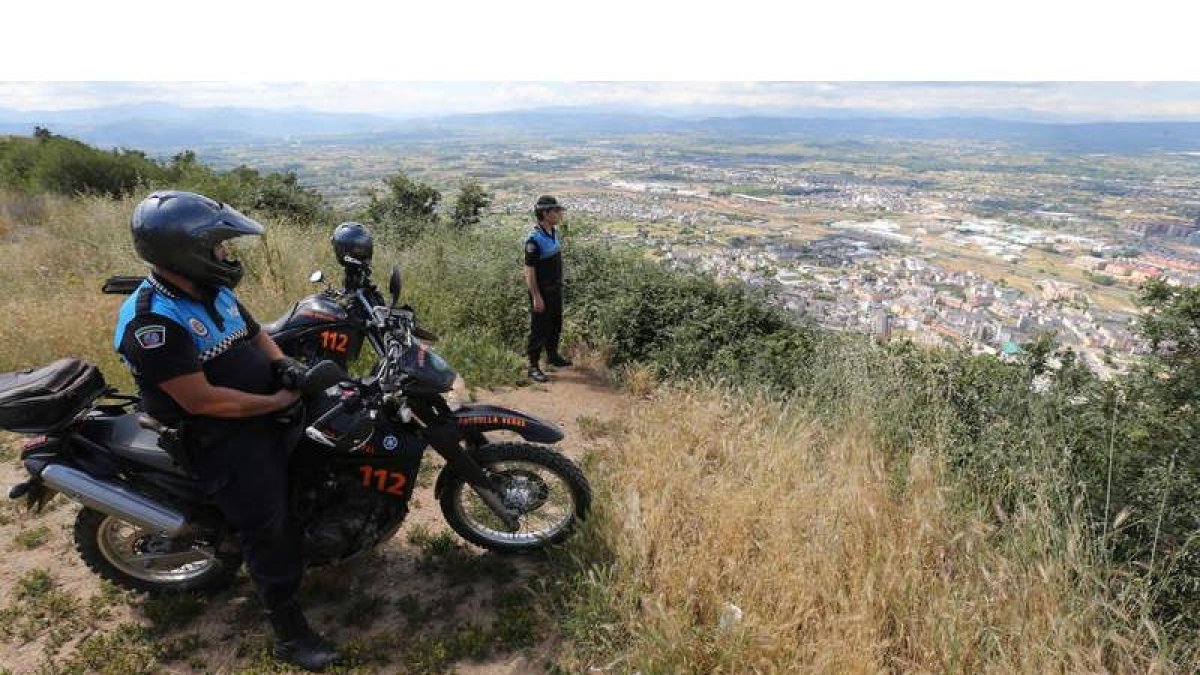 Dos agentes de la Policía Local de Ponferrada, ayer por la tarde en el alto del monte Pajariel, con magníficas vistas de la ciudad. mata